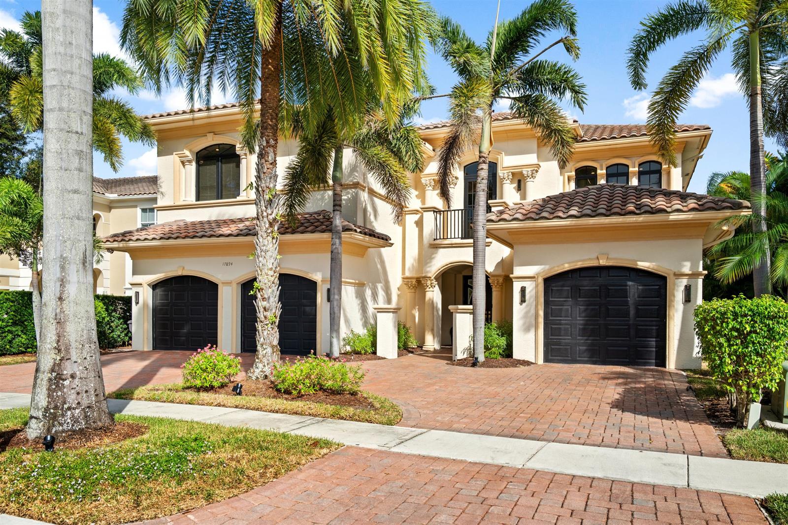 A two-story Mediterranean-style house features a brick driveway, three garage bays, and palm trees — 17894 Monte Vista Drive, Boca Raton FL 33496, BOCA RATON, FL