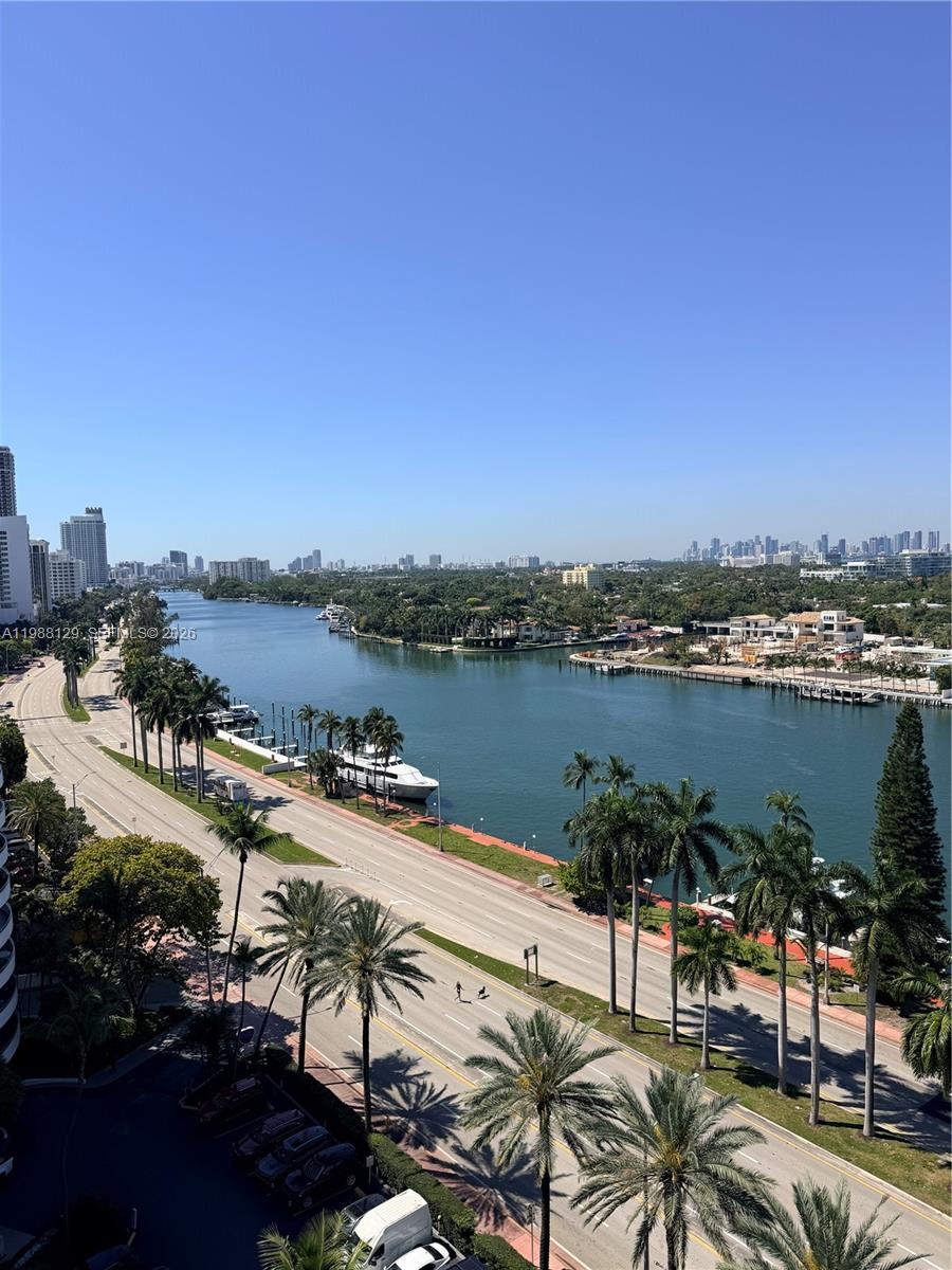 An elevated view shows a waterway lined with palm trees, a road, and distant city buildings — 5161 Collins Ave # 1506, Miami Beach FL 33140, MIAMI BEACH, FL