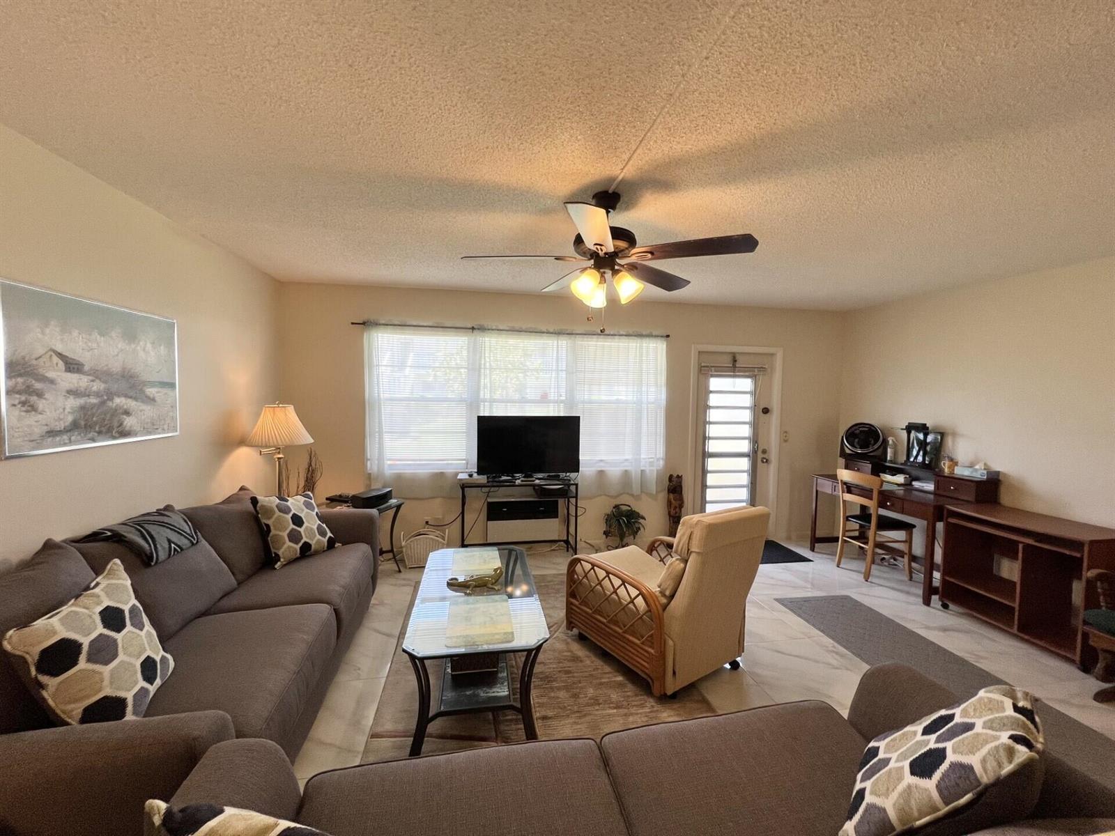 A living room features a gray sectional sofa, a glass coffee table, and a desk area — 3 Islewood A # 3, Deerfield Beach FL 33442, DEERFIELD BEACH, FL