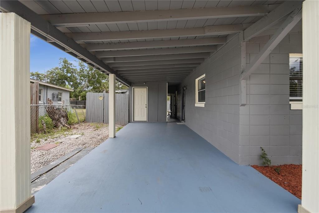 A covered concrete patio with gray walls and a white door attached to a house — 1401 RADLEIGH PLACE, ORLANDO, FL