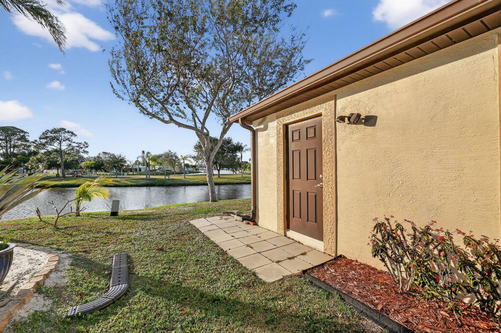 A brown door on the side of a tan house overlooks a small lake — 24 Azul, Fort Pierce FL 34951, FORT PIERCE, FL