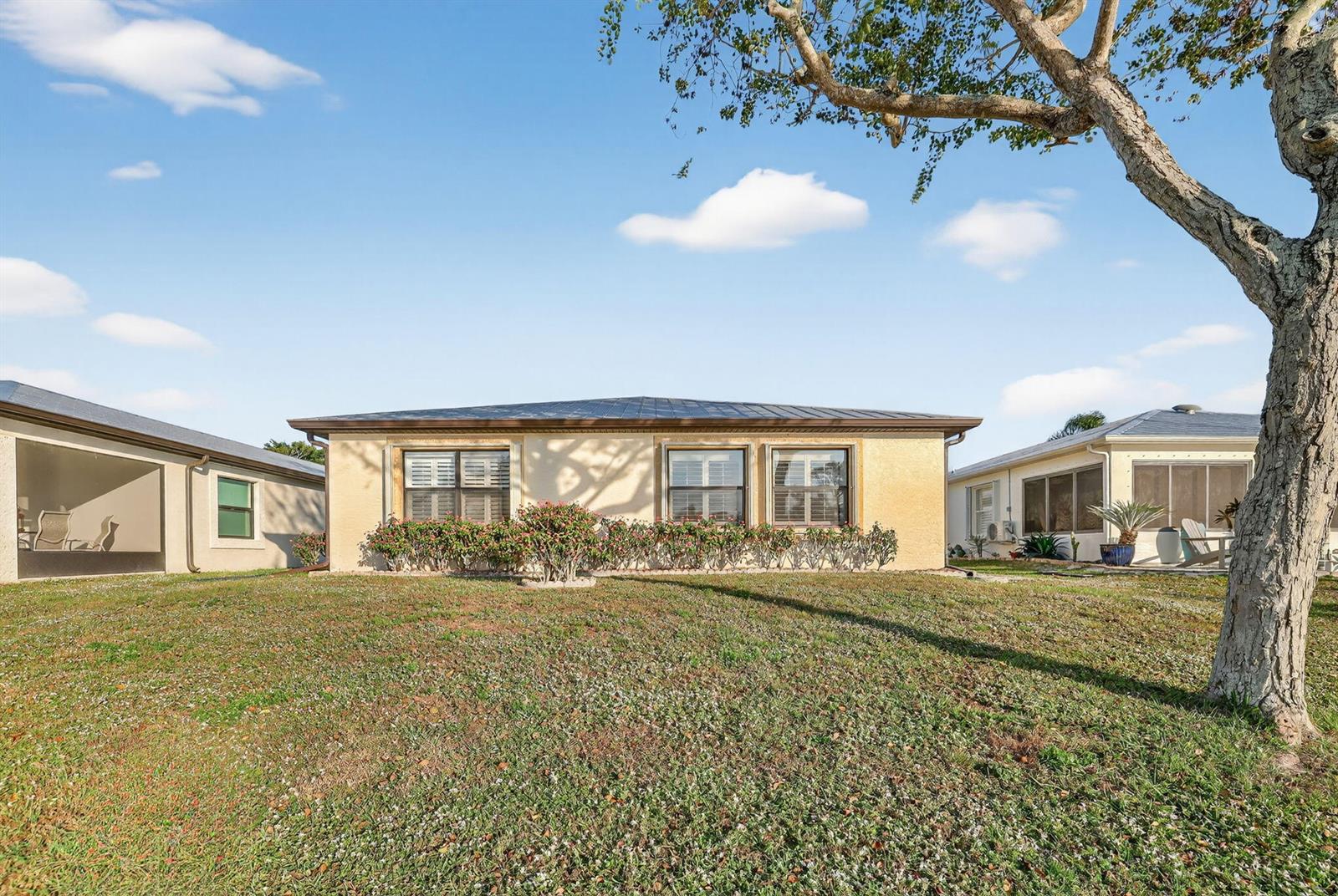 A single-story house with a tan stucco exterior and a dark metal roof — 24 Azul, Fort Pierce FL 34951, FORT PIERCE, FL