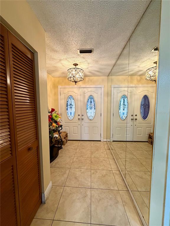 An entryway features a tiled floor, double front doors with glass inserts, and mirrored walls — 8026 JACKSON SPRINGS ROAD, TAMPA, FL