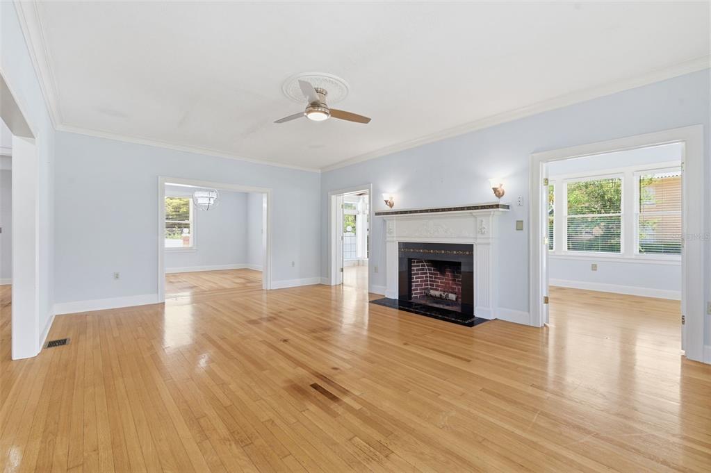 A living room features light blue walls, hardwood floors, and a white fireplace mantel — 555 18TH AVENUE NE, ST PETERSBURG, FL