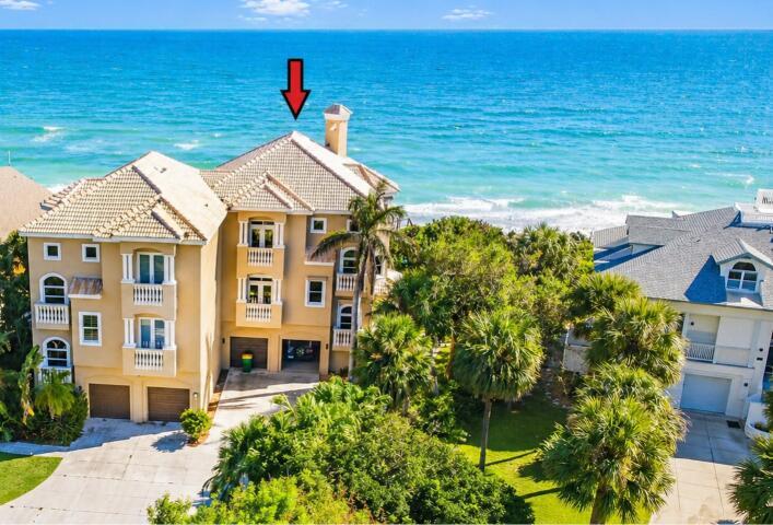 An aerial view of a multi-story tan house with a tiled roof near the ocean — 8327 S Hwy A1a, Melbourne Beach FL 32951, MELBOURNE BEACH, FL