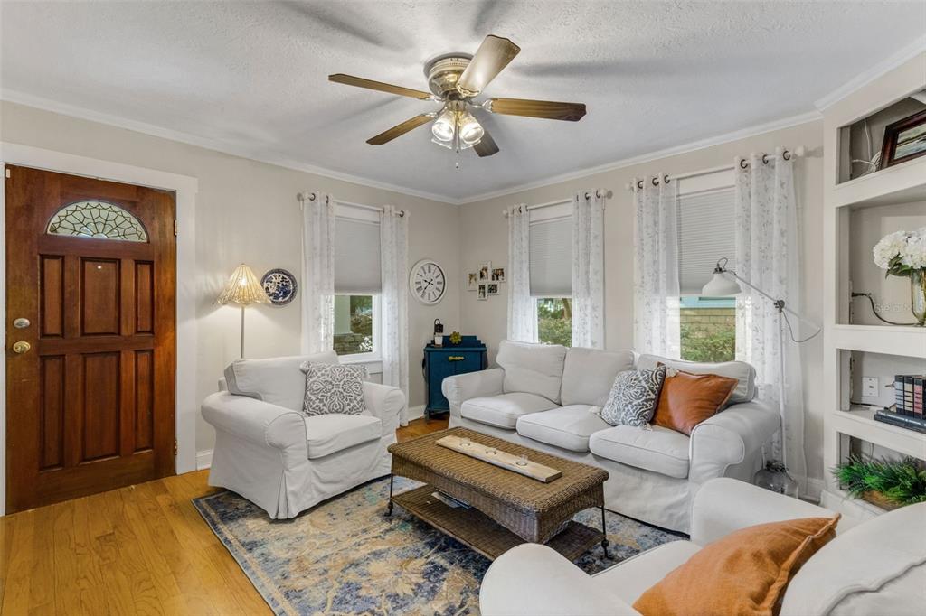 A living room features white sofas, a wicker coffee table, and a wooden front door — 717 JOHNSON AVENUE, LAKELAND, FL
