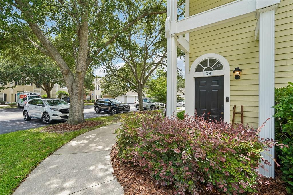 A sidewalk leads to the front entrance of a yellow house with a black door — 10000 SW 52ND AVENUE UNIT G38, GAINESVILLE, FL