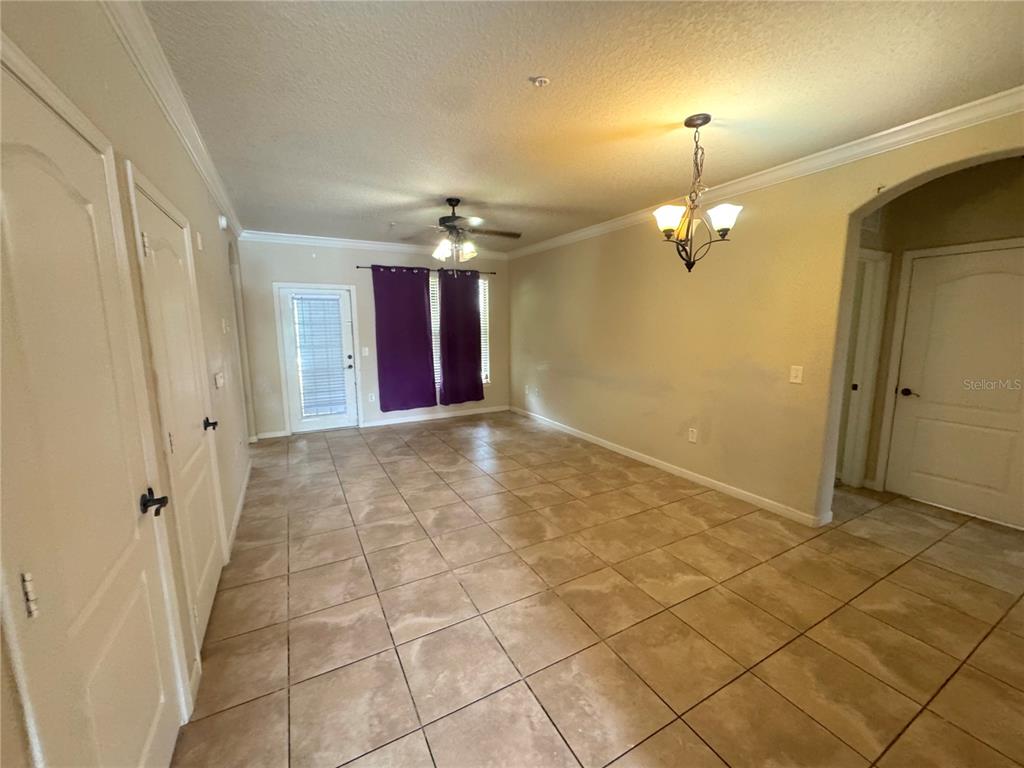 A dining area features tile flooring, a ceiling fan, and a chandelier — 909 CHARO PARKWAY UNIT 1016, DAVENPORT, FL