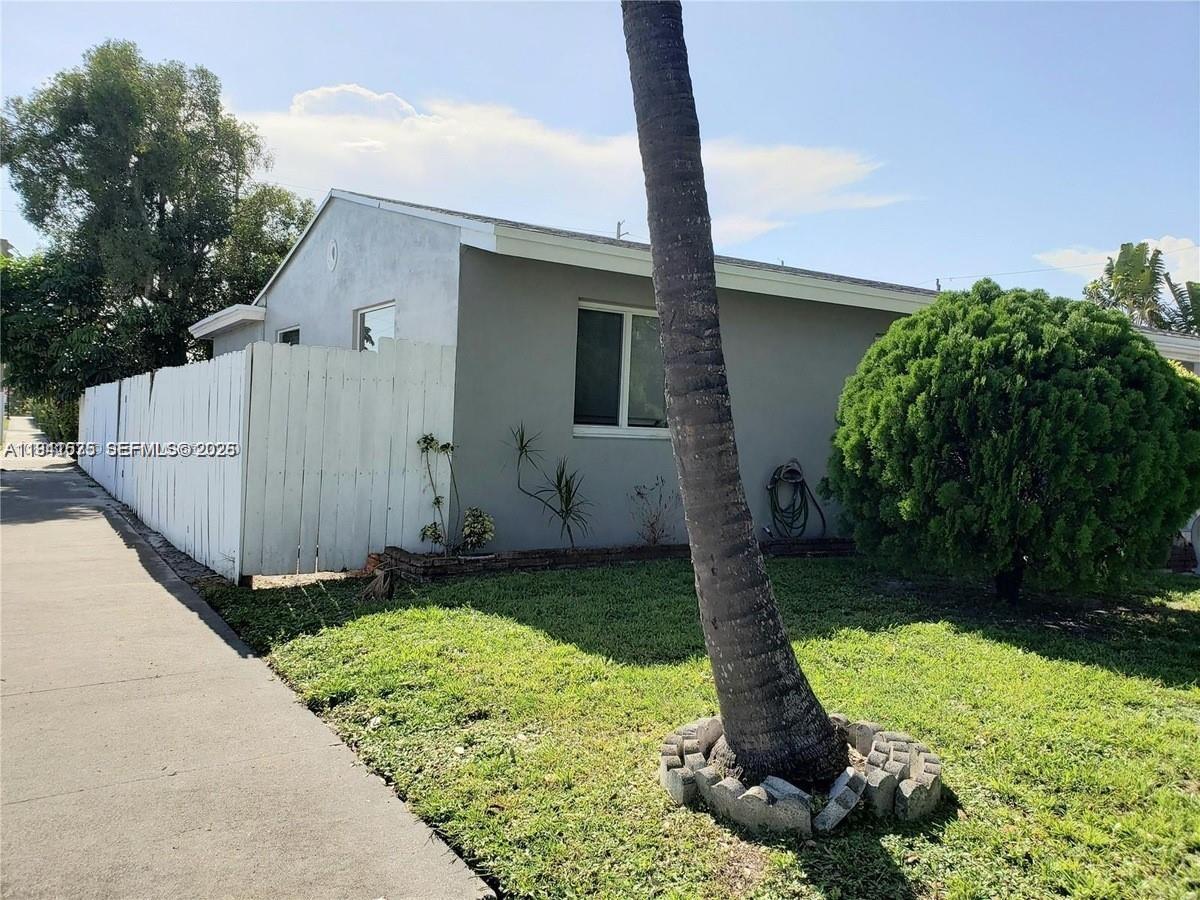 A single-story house exterior features a white fence, a palm tree, and a green lawn — 804 N 20th Ct, Hollywood FL 33020, HOLLYWOOD, FL