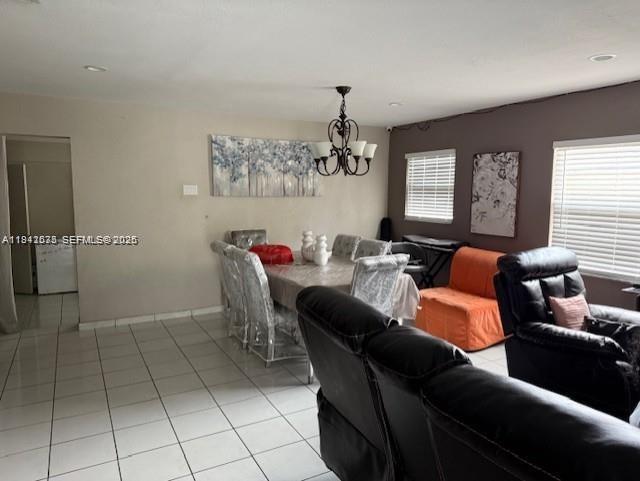 A dining area with a chandelier and a living room with black leather recliners — 804 N 20th Ct, Hollywood FL 33020, HOLLYWOOD, FL