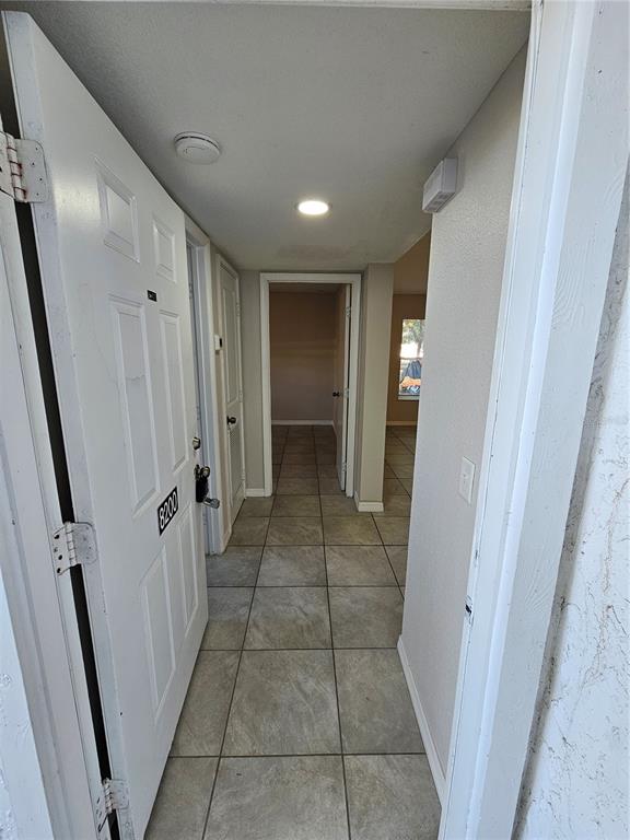 A view from an open doorway into a tiled hallway leading to an interior room — 8200 FAIRWAYS CIRCLE UNIT B102, OCALA, FL