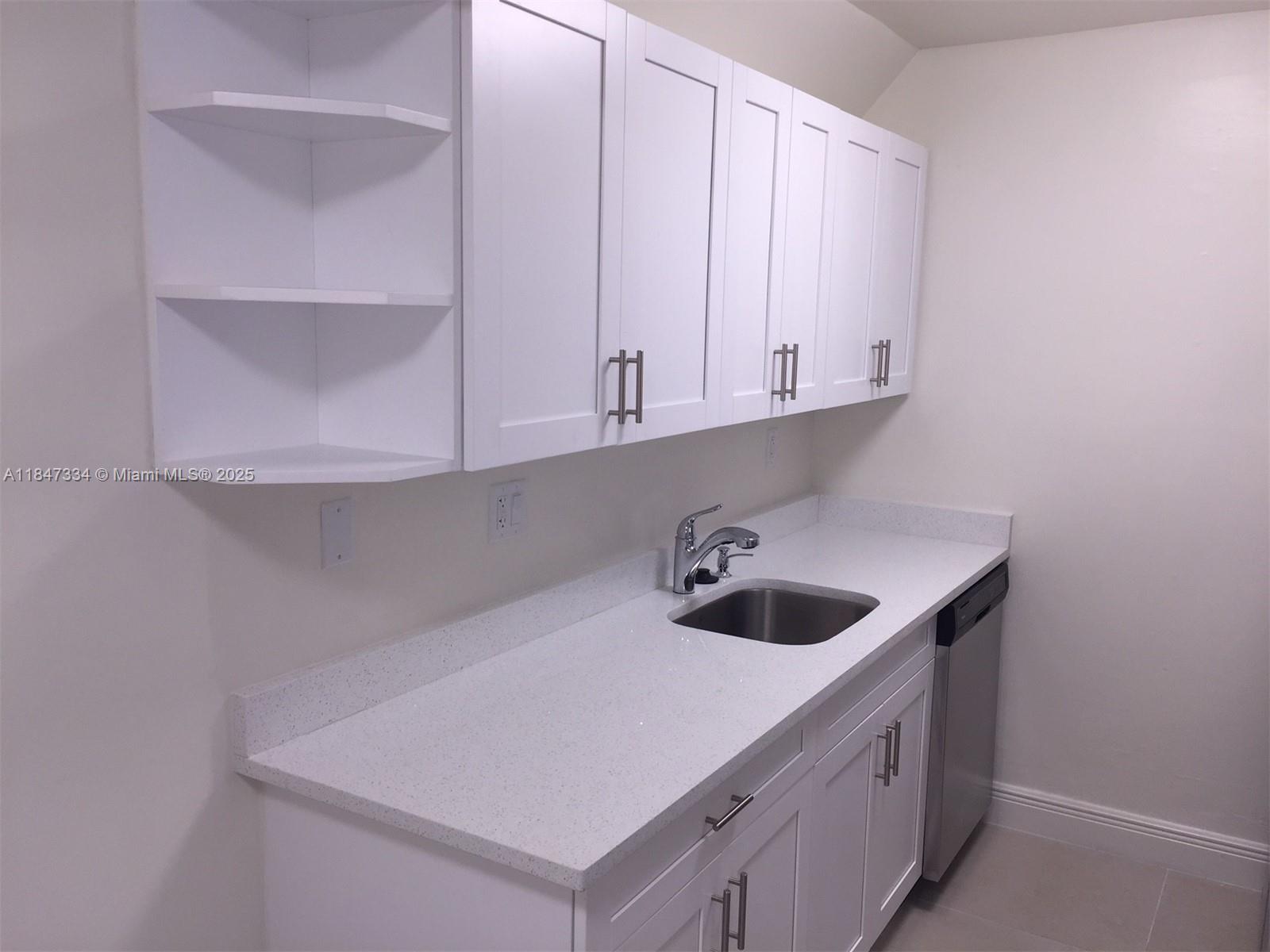 A kitchen features white cabinets, a speckled countertop, a stainless steel sink, and a dishwasher — 10740 N KENDALL DR # 14, Miami FL 33176, MIAMI, FL