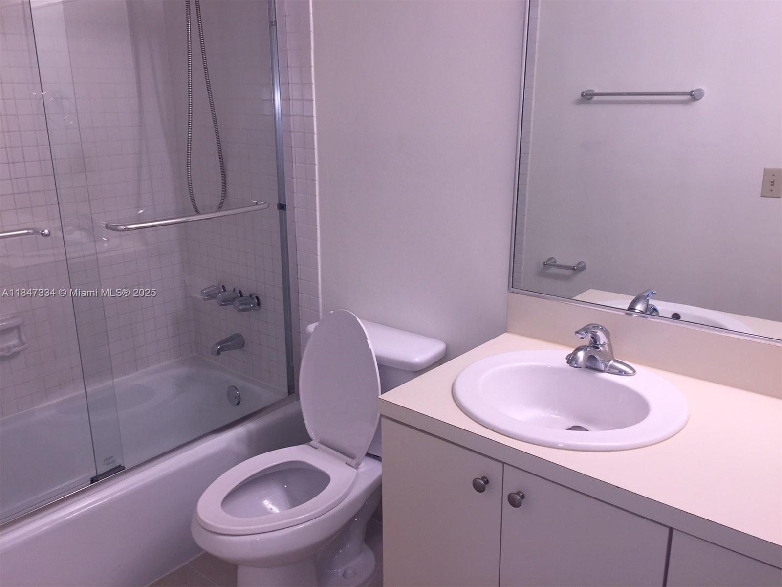A bathroom features a white vanity with a sink, a toilet, and a shower-tub combination — 10740 N KENDALL DR # 14, Miami FL 33176, MIAMI, FL