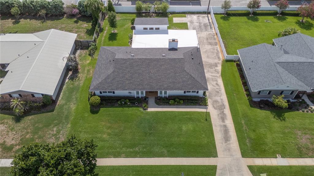 An aerial view shows a single-story house with a dark roof and a concrete driveway — 1211 HUNT AVENUE, LAKELAND, FL