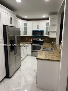 A kitchen with white cabinets, stainless steel appliances, and light-colored marble-patterned tile flooring — 1311 NE 210th Ter # A, Miami FL 33179, MIAMI, FL