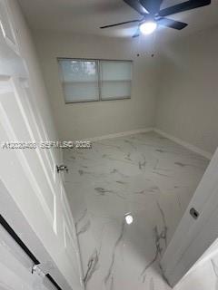 An empty room features white marble-look tile flooring, a ceiling fan, and a window — 1311 NE 210th Ter # A, Miami FL 33179, MIAMI, FL