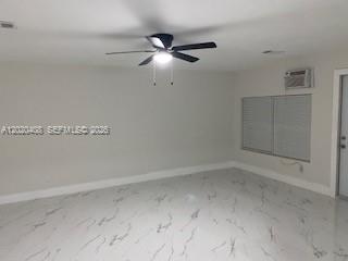 An empty room with white marble-patterned tile flooring, a ceiling fan, and a window unit — 1311 NE 210th Ter # A, Miami FL 33179, MIAMI, FL