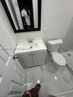 A bathroom features a white vanity, a toilet, and a mirror with a black frame — 1311 NE 210th Ter # A, Miami FL 33179, MIAMI, FL