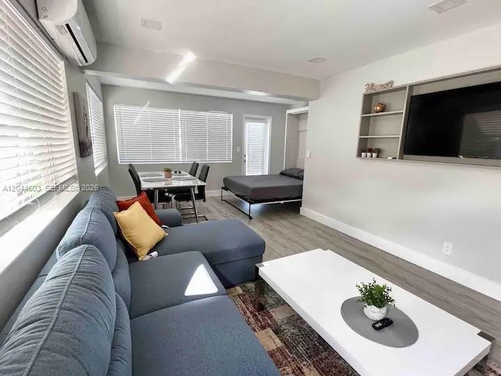A living room features a blue sectional sofa, a white coffee table, and a Murphy bed — 1925 Dewey St, Hollywood FL 33020, HOLLYWOOD, FL