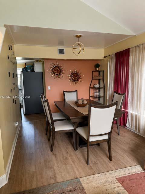 A dining room features a wooden table, four chairs, and sun-themed wall decor — 4351 Leicester Ct, West Palm Beach FL 33409, WEST PALM BEACH, FL