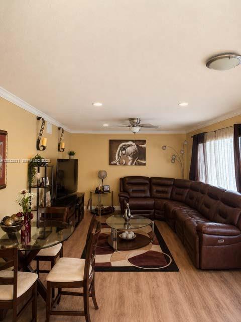 A living room features a brown sectional sofa, a glass dining table, and light wood flooring — 4351 Leicester Ct, West Palm Beach FL 33409, WEST PALM BEACH, FL
