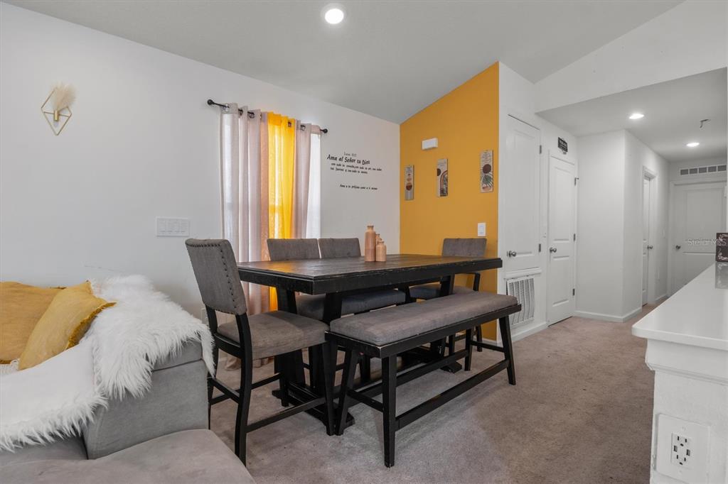 A dining area features a dark wood table with gray chairs and a bench — 1665 TEAGAN LANE, WINTER HAVEN, FL