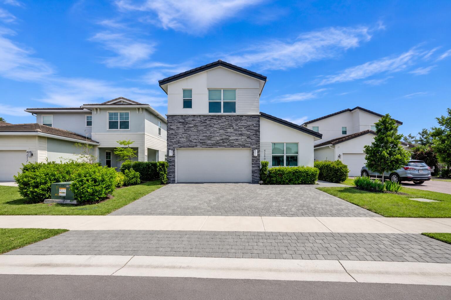 A two-story house with a stone facade, a two-car garage, and a paved driveway — 4206 Rosa Drive, Deerfield Beach FL 33064, DEERFIELD BEACH, FL