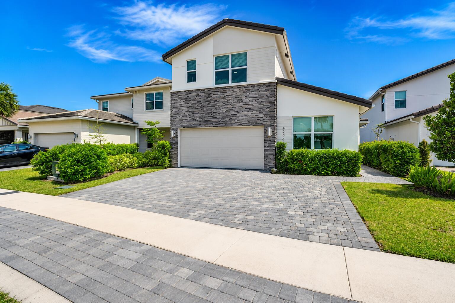 A two-story house with a stone facade, a two-car garage, and a paved driveway — 4206 Rosa Drive, Deerfield Beach FL 33064, DEERFIELD BEACH, FL