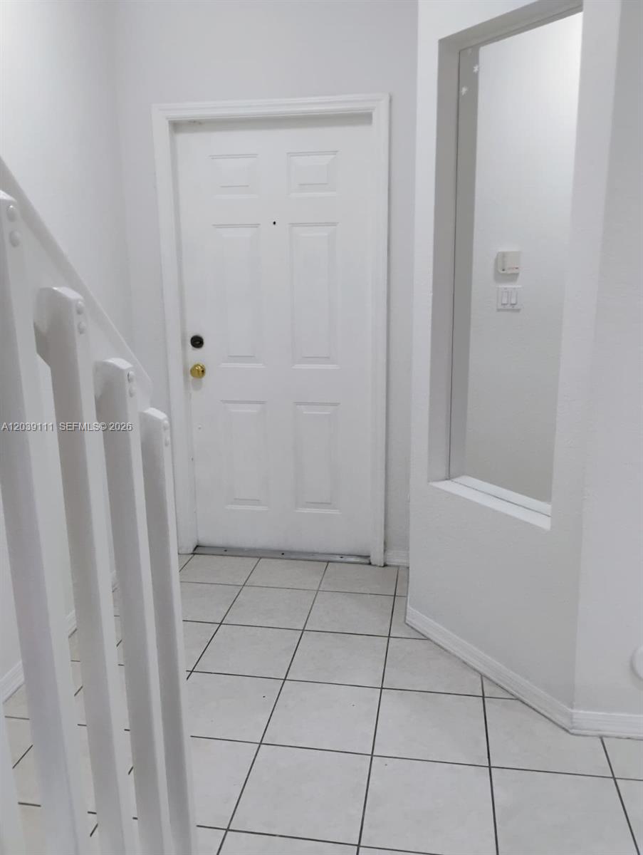 A white front door opens into a small entryway with white tile flooring — 5725 NW 114th Path # 107, Doral FL 33178, DORAL, FL