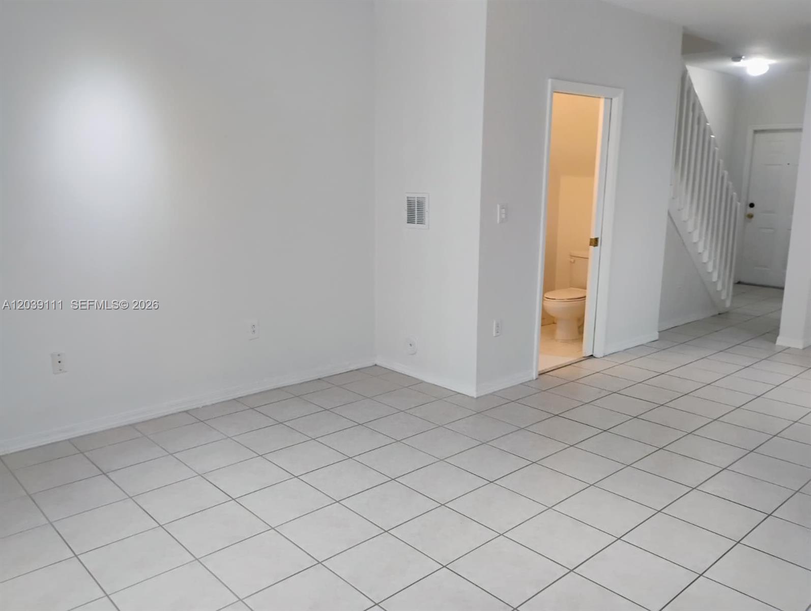 A room with white walls and tiled floors features a doorway leading to a bathroom — 5725 NW 114th Path # 107, Doral FL 33178, DORAL, FL