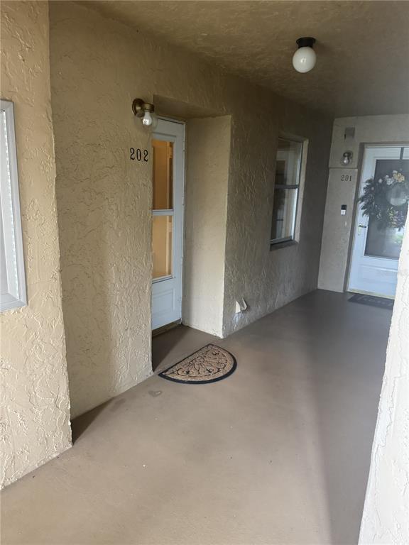 An exterior hallway shows two apartment unit doors numbered 202 and 201 — 90 S HIGHLAND AVENUE UNIT 202, TARPON SPRINGS, FL