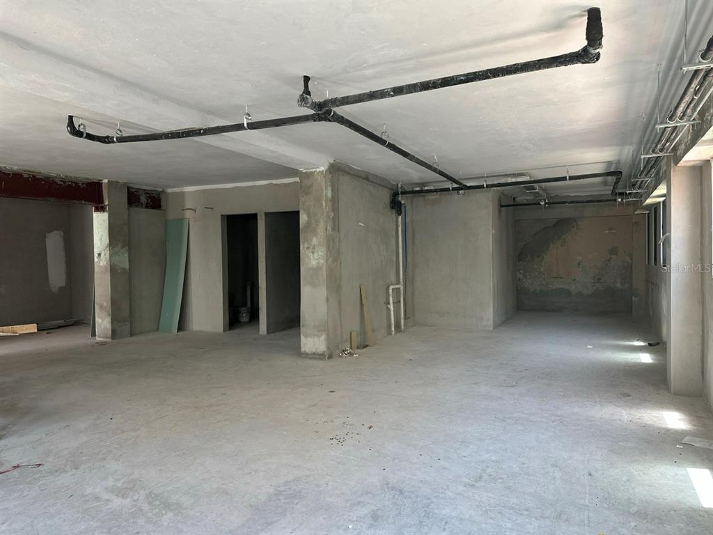 An unfinished interior space features exposed concrete walls, a concrete floor, and overhead plumbing pipes — 656 RH TODD UNIT 1, SAN JUAN, PR