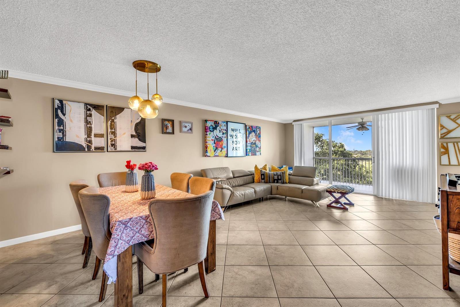 An open-concept living and dining area features tile flooring, a beige sectional, and balcony access — 3080 N Course Drive # 501, Pompano Beach FL 33069, POMPANO BEACH, FL