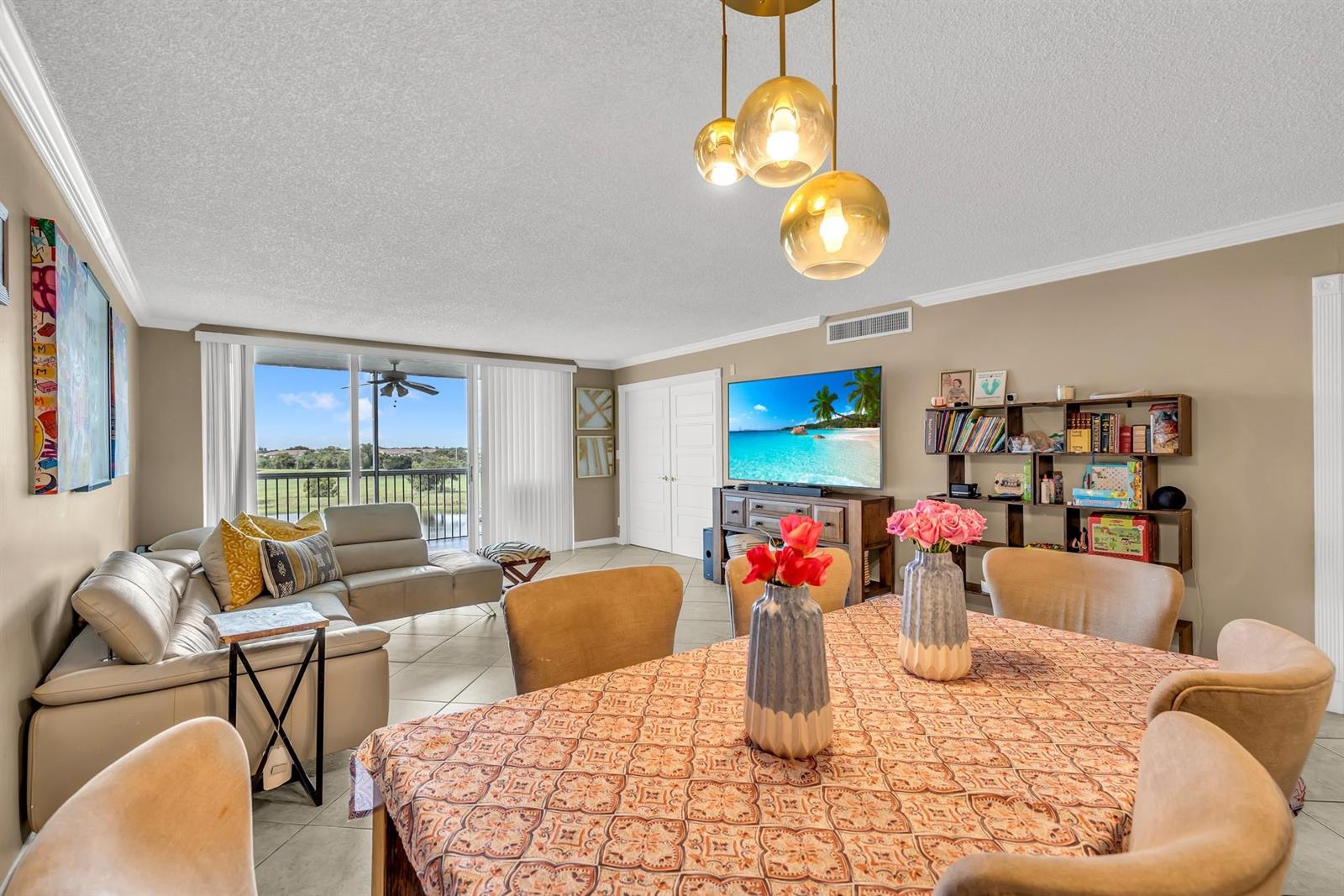 A living and dining area with tile floors, a sectional sofa, and a balcony view — 3080 N Course Drive # 501, Pompano Beach FL 33069, POMPANO BEACH, FL