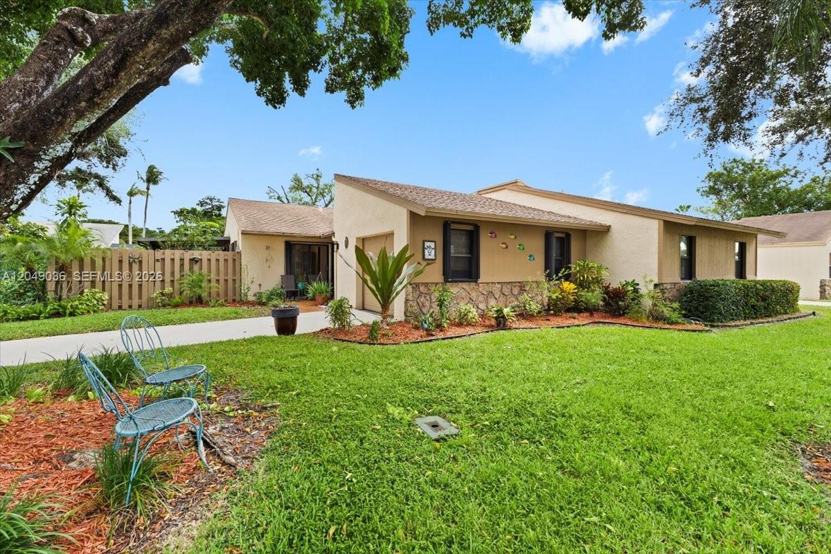 A single-story house with a stone facade, a concrete driveway, and a large front lawn — 901 NW 26th Ave, Delray Beach FL 33445, DELRAY BEACH, FL