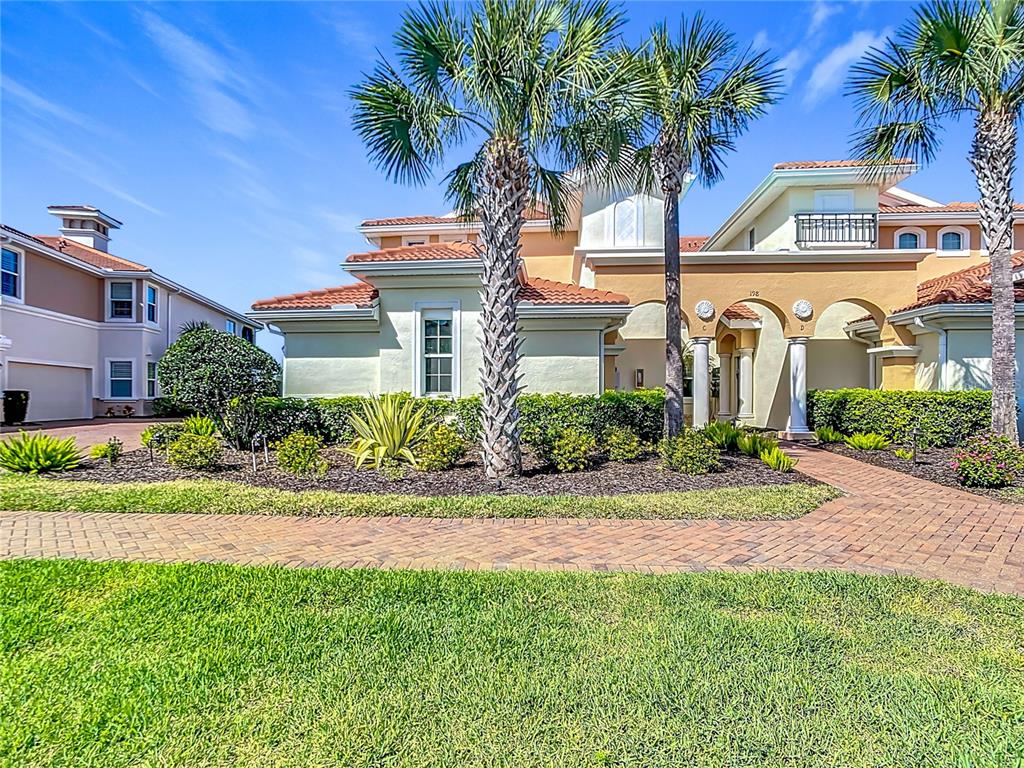 A two-story stucco house with a tile roof, palm trees, and a brick walkway — 198 BELLA VISTA TERRACE UNIT C, NORTH VENICE, FL