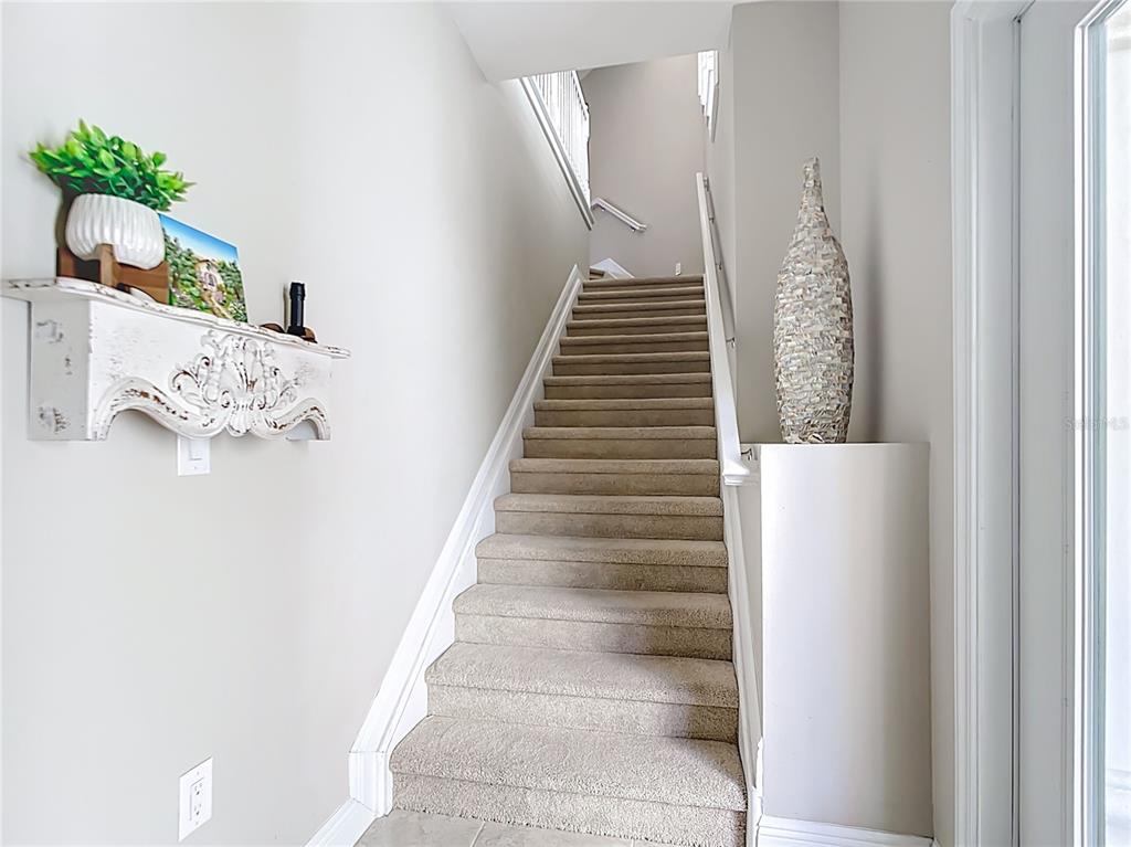 A carpeted staircase with white trim leads upward between two light-colored walls — 198 BELLA VISTA TERRACE UNIT C, NORTH VENICE, FL