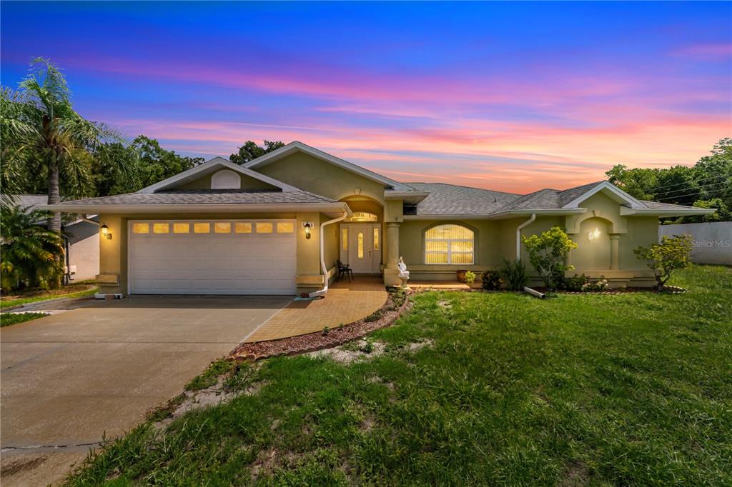 A single-story house with a two-car garage, arched entryway, and a paved walkway — 5146 WORTH COURT, NEW PORT RICHEY, FL