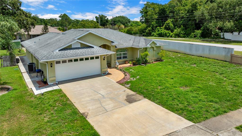 An aerial view of a single-story house with a green exterior, gray roof, and driveway — 5146 WORTH COURT, NEW PORT RICHEY, FL