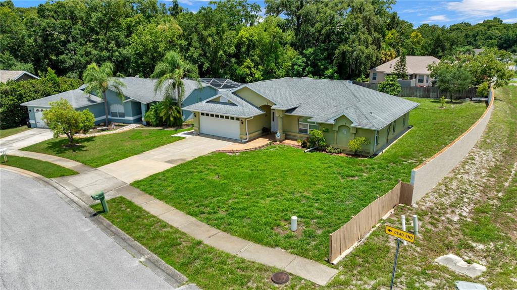 An aerial view shows two suburban houses with green lawns and a dead-end street sign — 5146 WORTH COURT, NEW PORT RICHEY, FL