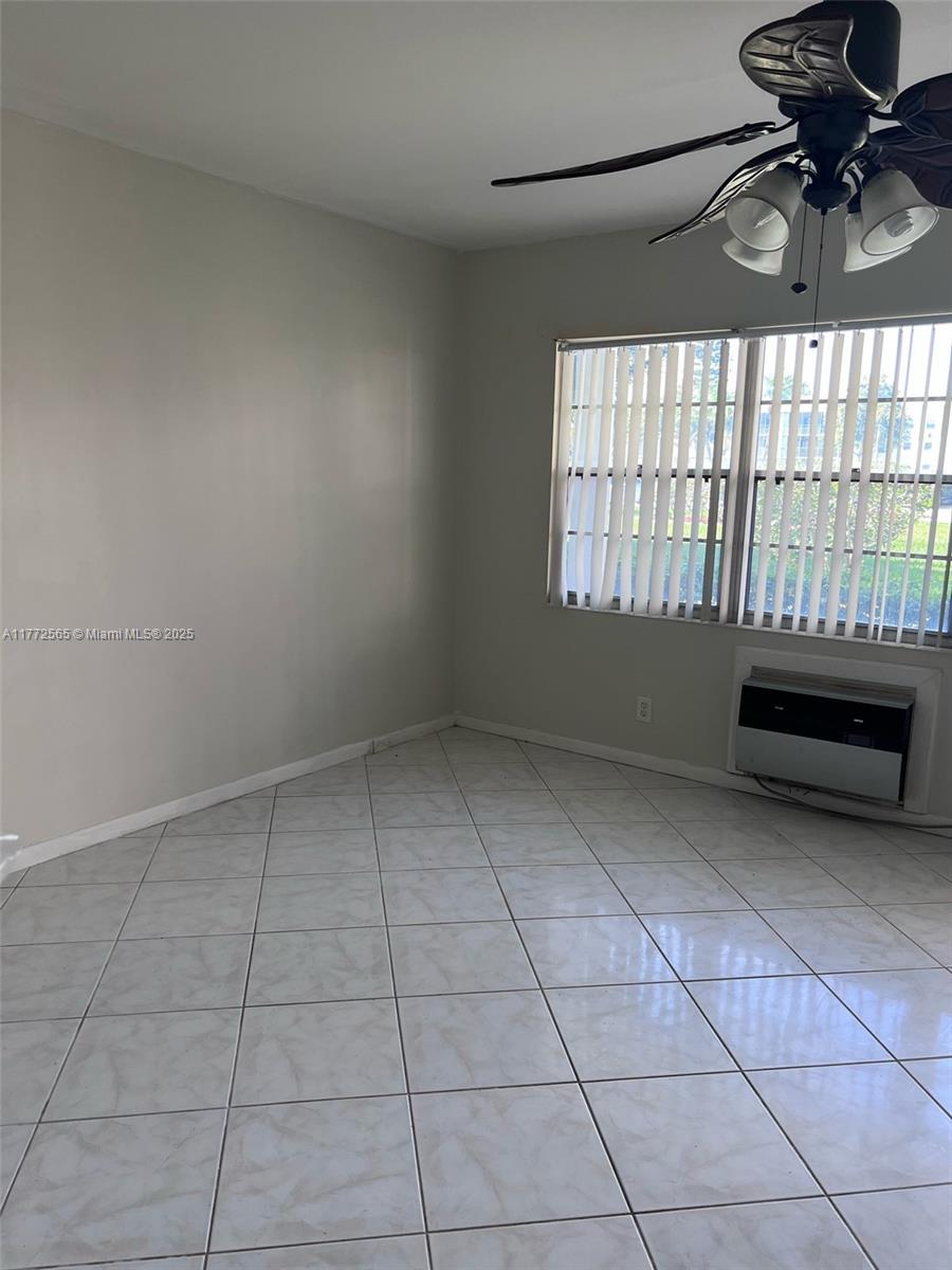 This room features light-colored tile flooring, a ceiling fan, and a window with vertical blinds — 90 Fanshaw C # 90, Boca Raton FL 33434, BOCA RATON, FL