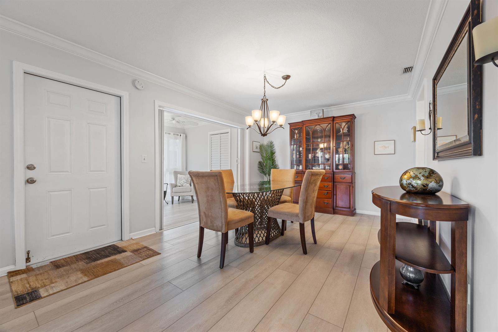 A dining room features a glass-topped table, upholstered chairs, a wooden hutch, and light flooring — 10116 46th Avenue S # 488, Boynton Beach FL 33436, BOYNTON BEACH, FL