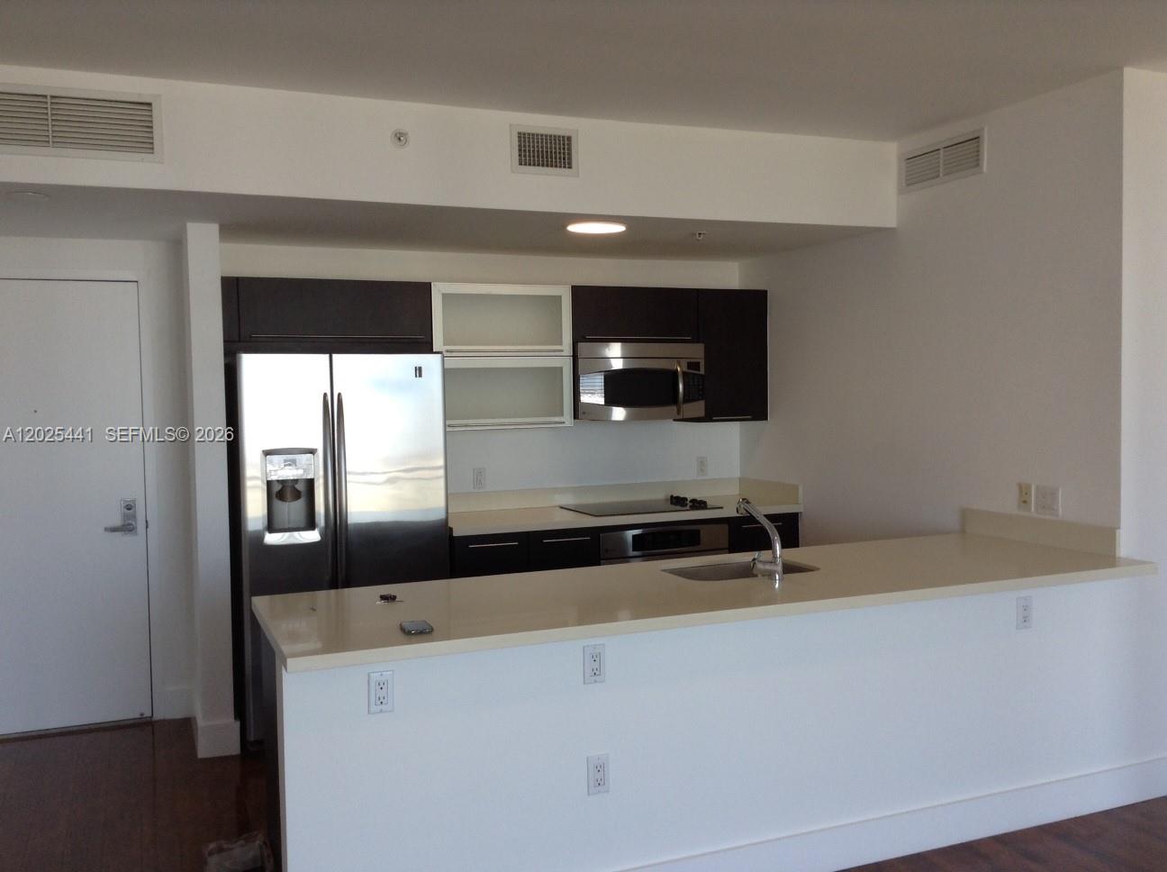 A kitchen features dark cabinets, stainless steel appliances, and a white countertop island — 90 SW 3rd St # 3708, Miami FL 33130, MIAMI, FL