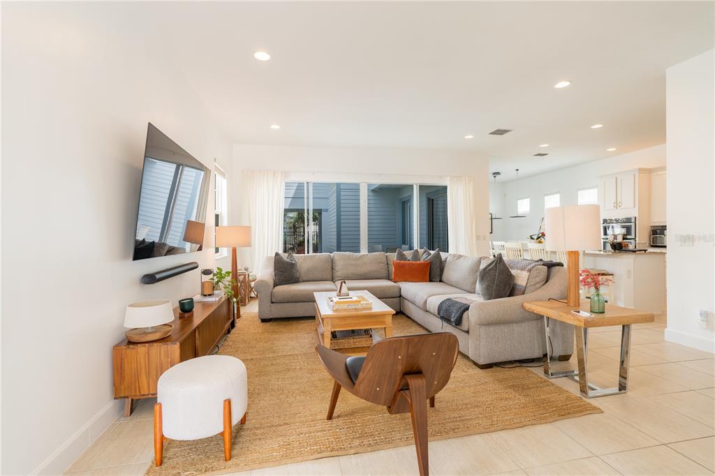 A living room with a sectional sofa, television, and open access to the kitchen — 1545 FAIRVIEW CIRCLE, REUNION, FL
