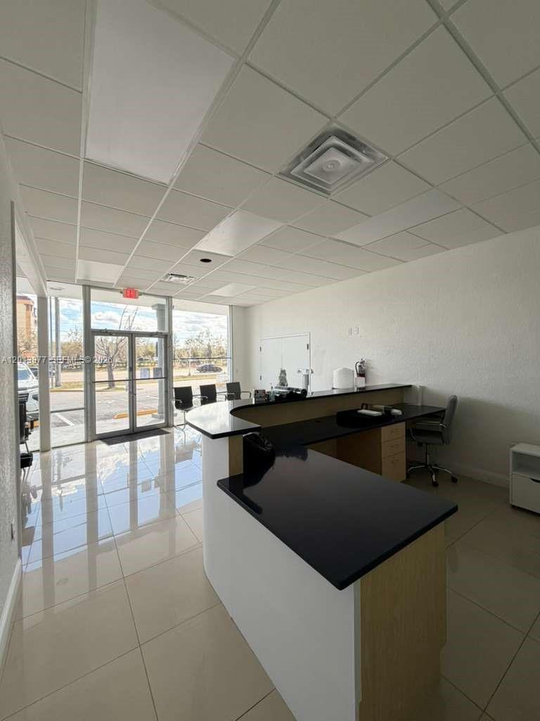 A commercial office space features a reception desk, tile flooring, and a glass-paneled entrance door — 2003 MCCOY RD # D, Orlando FL 32809, ORLANDO, FL