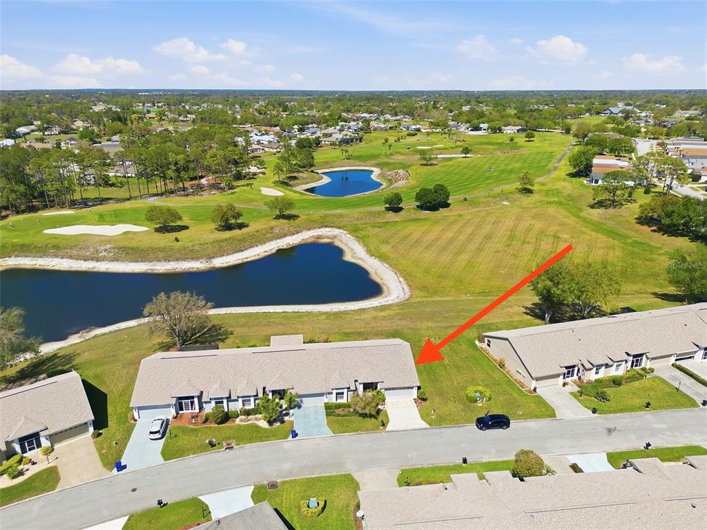 An aerial view shows a residential duplex building with a red arrow pointing toward it — 11131 HOLLANDER AVENUE, HUDSON, FL