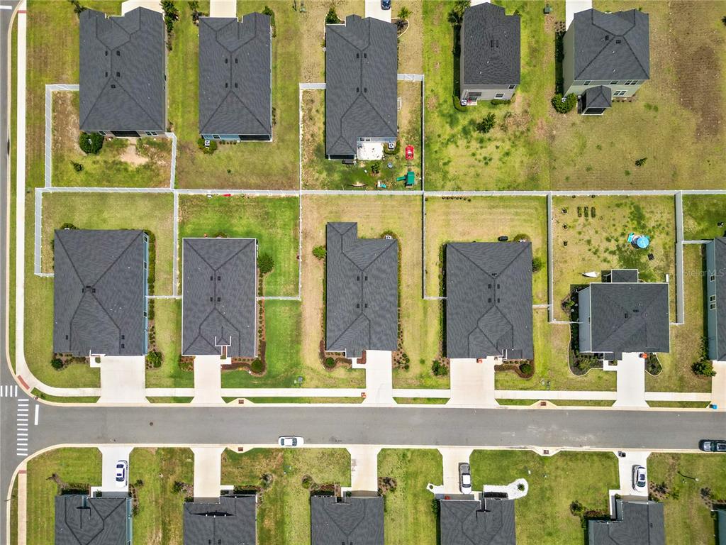 This aerial view shows a residential neighborhood with several detached houses and their backyards — 9324 SW 58TH CIRCLE, OCALA, FL