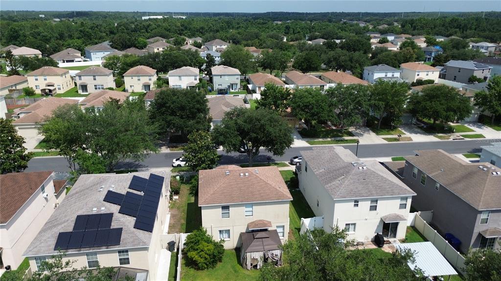 An aerial view shows a suburban neighborhood with several two-story houses and solar panels — 9631 SIMEON DRIVE, LAND O LAKES, FL