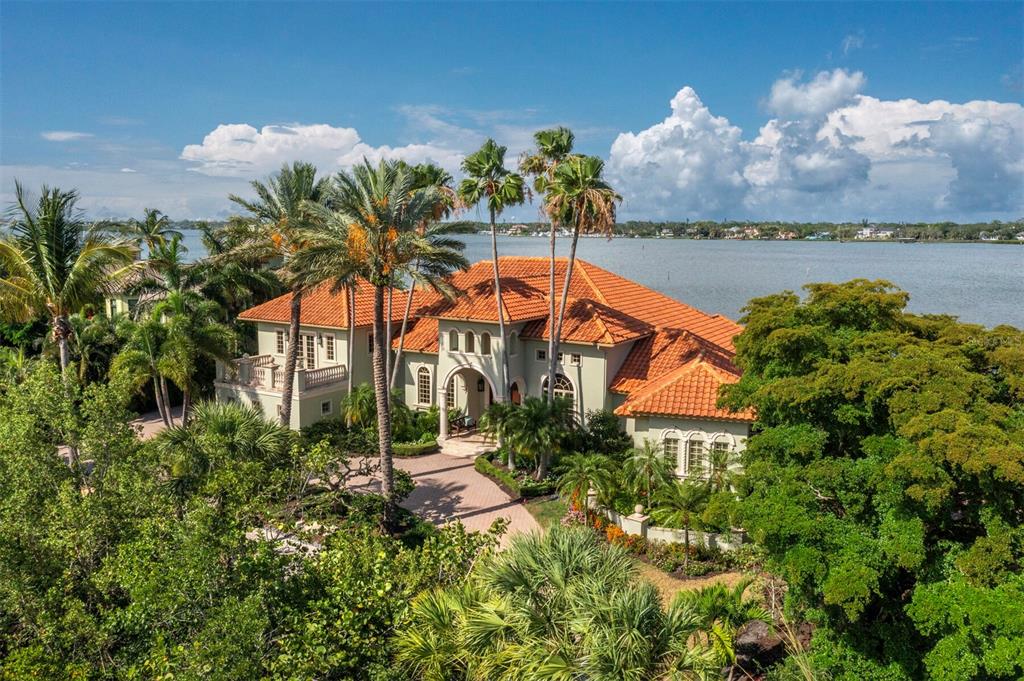 An aerial view of a two-story Mediterranean-style house with a red tile roof near water — 1280 HIDDEN HARBOR WAY, SARASOTA, FL