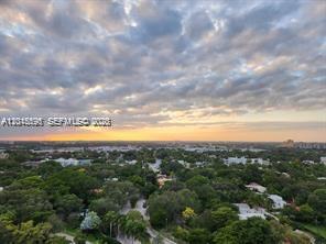 An aerial view of a lush green landscape under a cloudy sunset sky — 780 NE 69th St # 1810, Miami FL 33138, MIAMI, FL
